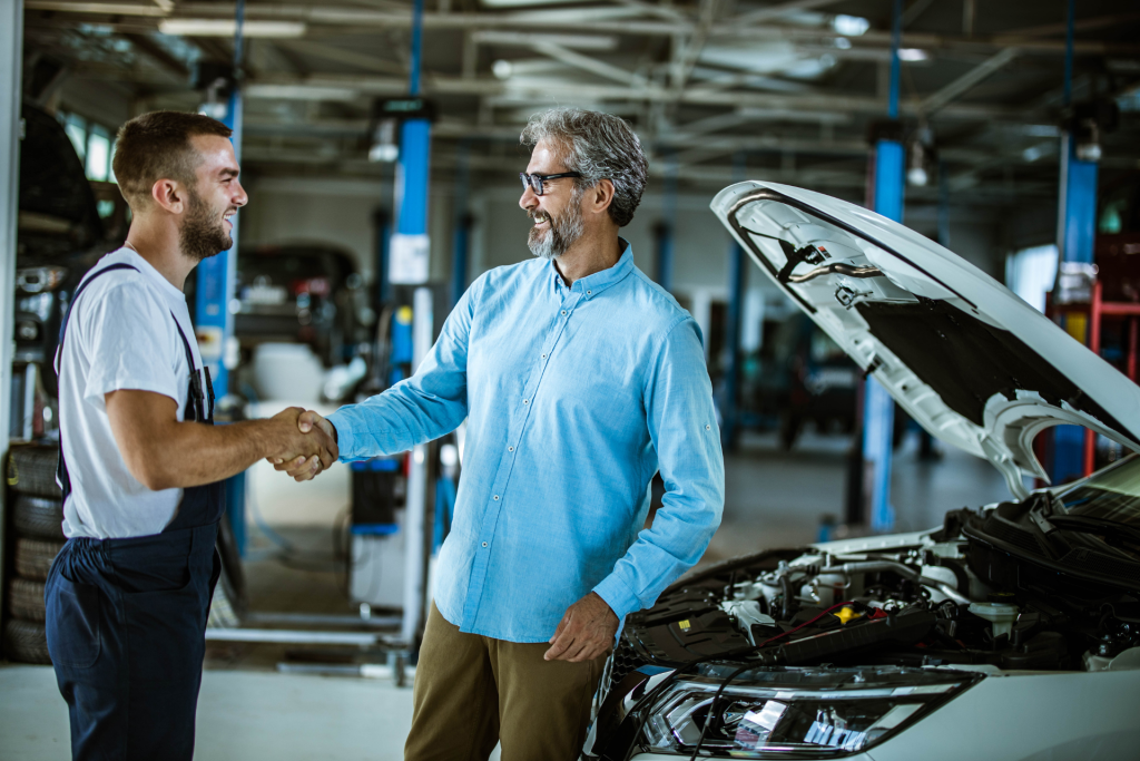 Customer shaking hands with a mechanic in an auto repair shop